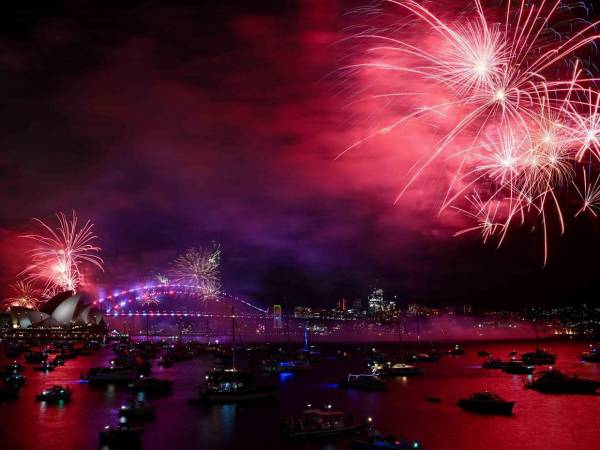 Fuegos artificiales iluminan el Puente del Puerto y la Ópera en una espectacular bienvenida al 2025.