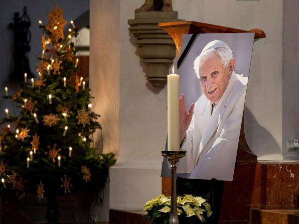 Una fotografía del papa emérito Benedicto XVI se ve durante una oración en la Iglesia Catedral de Nuestra Señora (Frauenkirche) el 31 de diciembre de 2022 en Munich, Alemania. El papa Emérito Benedicto XVI, un teólogo alemán cuya renuncia en 2013 tomó al mundo por sorpresa, murió el 31 de diciembre de 2022 a la edad de 95 años, anunció el Vaticano.