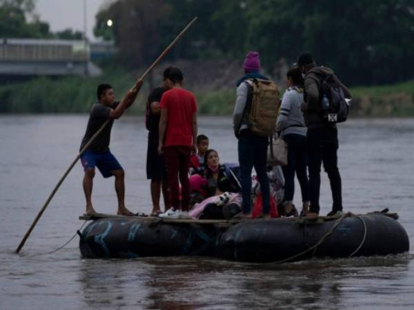 Migrantes y viajeros cruzan el río Suchiate, que marca la frontera entre Guatemala y México, desde Tecun Uman, Guatemala, domingo 6 de junio de 2021. (AP Foto/Moises Castillo)