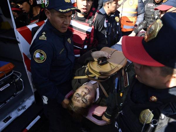 Una mujer herida es sacada de la estación del metro Indios Verdes luego de que dos trenes chocaran en la Ciudad de México.