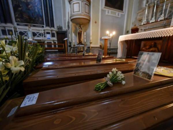 Coffins wait to be transported to cemetery, in the church of Serina, near Bergamo, Northern Italy, Saturday, March 21, 2020. Italyâs tally of coronavirus cases and deaths keeps rising, with new day-to-day highs: 793 dead and 6,557 new cases. For most people, the new coronavirus causes only mild or moderate symptoms. For some it can cause more severe illness. (Claudio Furlan/LaPresse via AP)