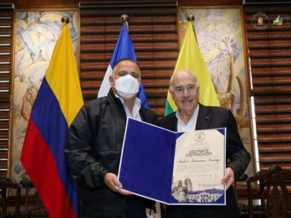 Momento en que el expresidente colombiano recibía el reconocimiento de manos del alcalde de San Pedro Sula.