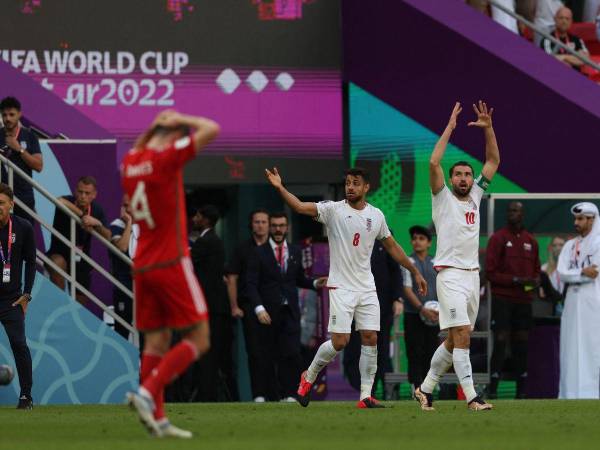 El defensor iraní #08 Morteza Pouraliganji y el delantero iraní #10 Karim Ansarifard reaccionan durante el partido de fútbol del Grupo B de la Copa Mundial Qatar 2022 entre Gales e Irán en el Estadio Ahmad Bin Ali en Al-Rayyan, al oeste de Doha el 25 de noviembre de 2022.