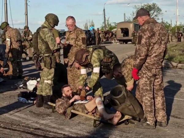 Esta captura de pantalla obtenida de un video informativo publicado por el Ministerio de Defensa de Rusia el 17 de mayo de 2022 muestra a miembros del servicio ucranianos mientras son registrados por personal militar prorruso después de salir de la planta siderúrgica Azovstal sitiada en la ciudad portuaria de Mariupol en Ucrania.