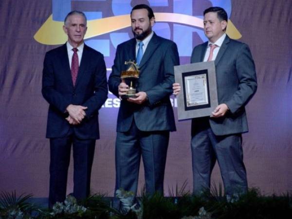 Roberto Alvarado y Carlos García, directivos de Loto, reciben el galardón.