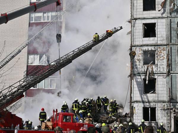 Los equipos de rescate buscan supervivientes entre los escombros junto a un edificio residencial dañado en Uman, al sur de Kiev.