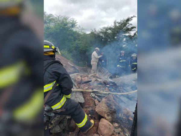 Miembros del Cuerpo de Bomberos intentando apagar las llamas.