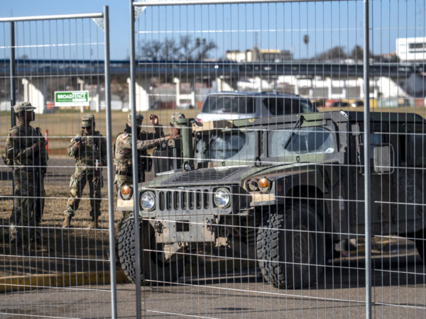 Miembros de la Guardia Nacional de Texas vigilan detrás de una cerca en Shelby Park el 3 de febrero de 2024 en Eagle Pass, Texas .