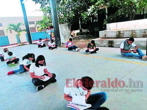 Los alumnos permanecen sentados en el piso cuando reciben clases en el gimnasio.