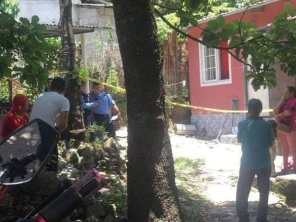 Vecinos y agentes policiales consternados fuera de la vivienda donde ocurrió la doble tragedia.