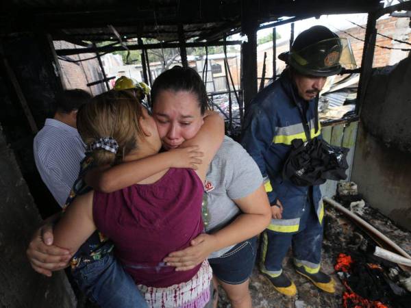 Una vecina abraza a una de las damnificadas mientras esta llora al saber que estuvo a punto de morir carbonizada con sus hijos.