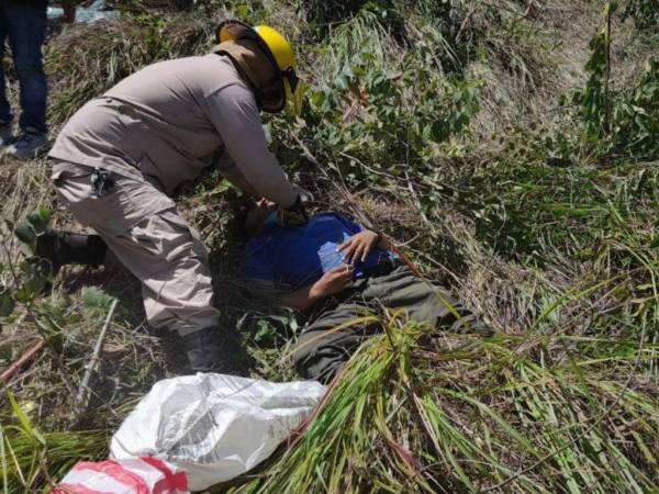 Un elemento del Cuerpo de Bomberos realiza primeros auxilios a un herido.