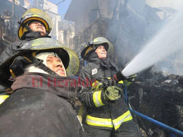 Bomberos tratan de sofocar las llamas en incendio que arrasó con unas seis viviendas en la capital.