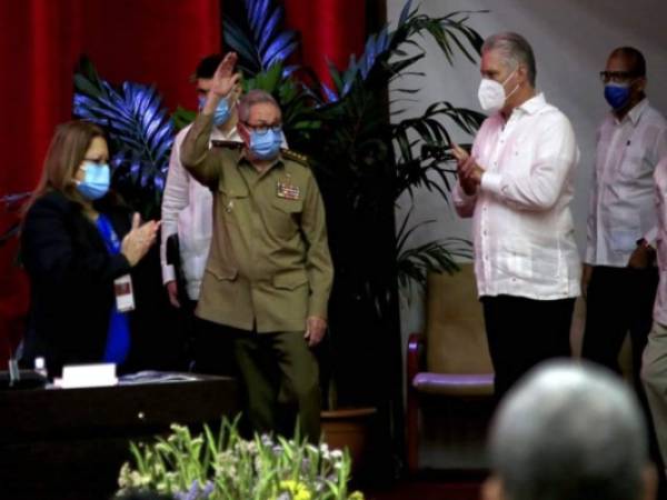 Raúl Castro, primer secretario del Partido Comunista y expresidente de Cuba, saluda a los miembros en la sesión inaugural del VIII Congreso del Partido Comunista de Cuba, mientras el presidente cubano Miguel Díaz-Canel, derecha, aplaude en el Palacio de Convenciones, en La Habana, Cuba, el viernes 16 de abril de 2021. (Ariel Ley Royero/ACN vía AP).