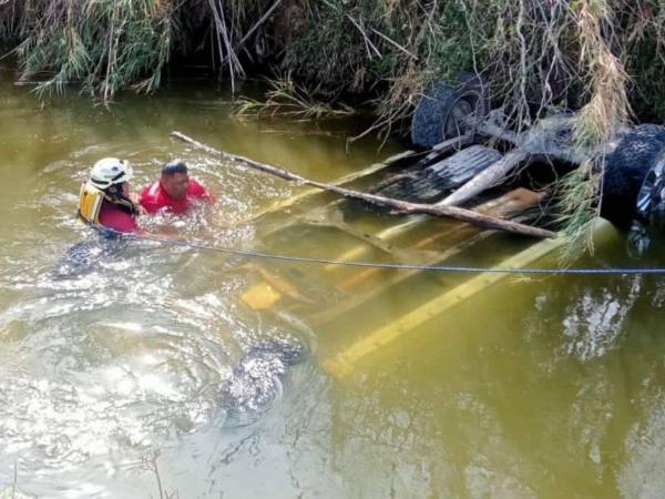 Autoridades intentan sacar del agua el vehículo en el que viajaban los migrantes hacia Estados Unidos.