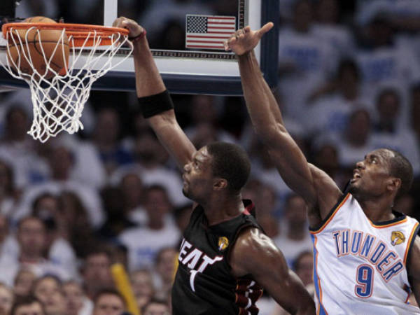 Miami Heat power forward Chris Bosh dunks against Oklahoma City Thunder power forward Serge Ibaka (9) from Republic of Congo during the first half at Game 2 of the NBA finals basketball series, Thursday, June 14, 2012, in Oklahoma City. (AP Photo/Jeff Roberson)