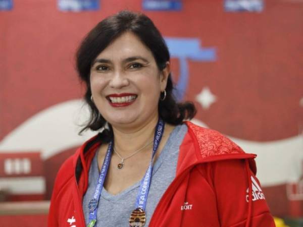 Confederations Cup volunteer Mathilde Molla smiles at the Spartak Stadium in Moscow, Sunday, June 25, 2017. She has been at the World Cup, European Championship, Olympic Games and Confederations Cup. It's not some extraordinary player or coach. Rather, a super-volunteer. Mathilde Molla, a 54-year old Brazilian, developed a passion for volunteering at international tournaments after her first event in the 2013 Confederations Cup in her native country. She was back at it a year later at the World Cup in Brazil, volunteered at the 2014 South American Games in Santiago, Chile, the 2015 Pan American Games in Toronto, the 2016 Euros in France and is now in Russia for her second Confederations Cup. (AP Photo/Alexander Zemlianichenko)