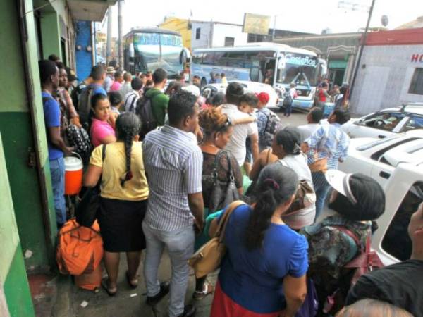 Pasajeros esperan para abordar estas dos unidades con rumbo a la zona norte y atlántico de Honduras. Foto: Johny Magallanes / El Heraldo.