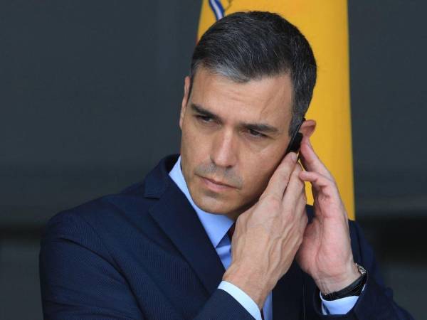 El presidente del Gobierno español, Pedro Sánchez, se coloca el auricular durante una conferencia de prensa en la Base de la Fuerza Aérea de Lituania en Siauliai, Lituania. España dijo el 2 de mayo de 2022 que los teléfonos móviles del presidente del Gobierno, Pedro Sánchez, y de la ministra de Defensa, Margarita Robles, fueron intervenidos con el software espía Pegasus en una intervención “ilícita y externa”.