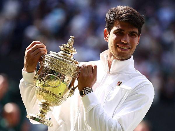 El español Carlos Alcaraz posa con el trofeo del ganador después de vencer al serbio Novak Djokovic durante la final masculina de tenis individual en el decimocuarto día del Campeonato de Wimbledon 2024.