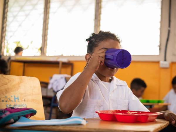 <i>Estudiante escolar disfrutando de su ración gracias al Programa Nacional de Alimentación Escolar.</i>