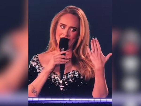 Adele mostró su enorme anillo de compromiso durante su concierto en Alemania.