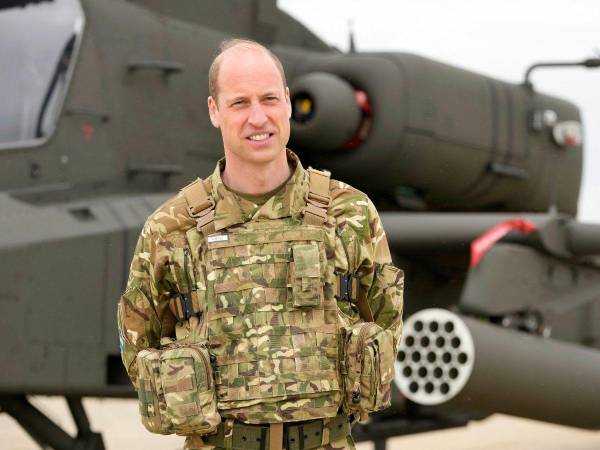 Príncipe William posa frente al helicóptero Apache tras recibir su título de coronel en jefe del Cuerpo Aéreo del Ejército.