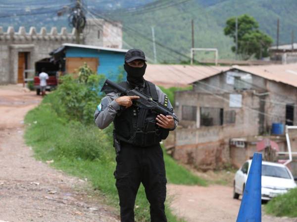 Un agente policial vigila una de las peligrosas calles de la colonia Mirador de Oriente, donde fueron raptados cinco jóvenes y luego asesinados.