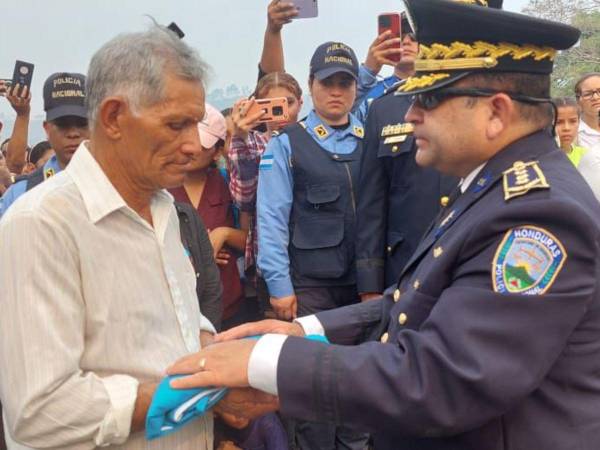 El padre del joven policía recibe el Pabellón Nacional en honor a la labor de su hijo.