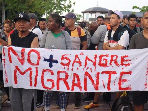 Migrantes sostiene un cartel durante una caravana rumbo a Estados Unidos, este martes, en el municipio de Tapachula en el estado de Chiapas (México) coincidendo con el proceso electoral que se desarrolla en EUA.