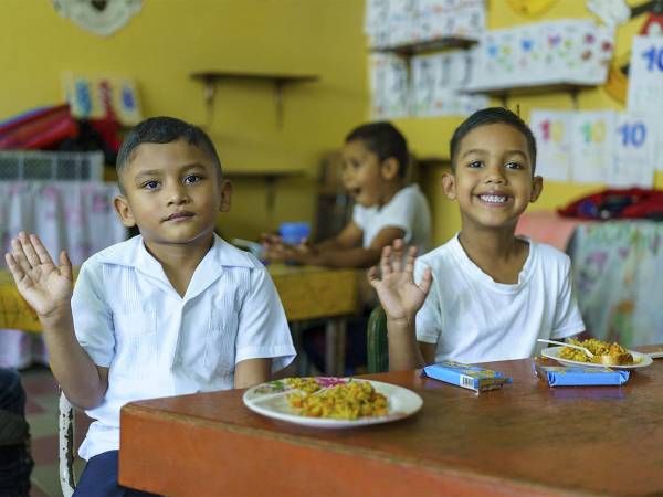 <i>Niños de Fundación Ficohsa disfrutando de la merienda escolar proporcionada por el programa.</i>