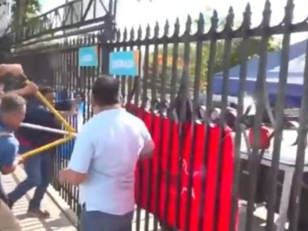 Momento en que empleados de Arsa intentan romper los candados e ingresar a la fuerza a las instalaciones.