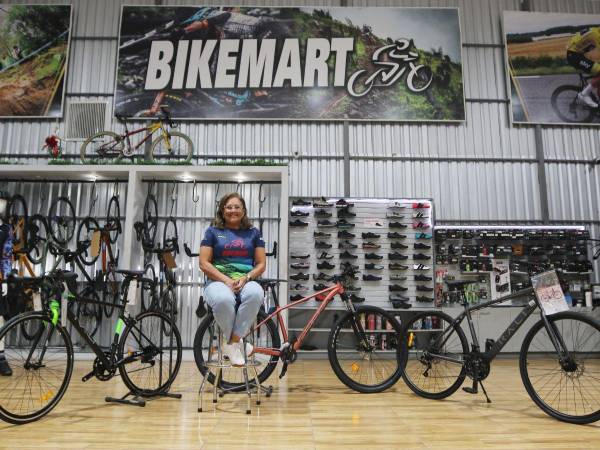 Gennie Flores posando en Bike Mart con los modelos de bicicletas que se sortearán en la Vuelta.