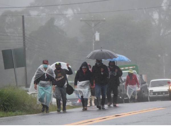 Fotografía de archivo en donde un grupo de personas camina por una vía tras las fuertes lluvias en Chiriquí (panamá).