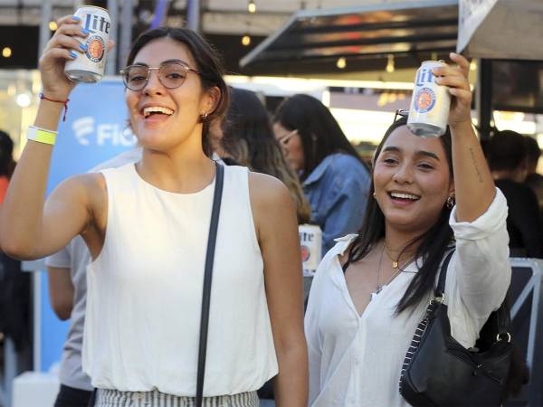 <i>Amigas brindando con Miller Lite mientras disfrutan de las presentaciones musicales en el festival.</i>