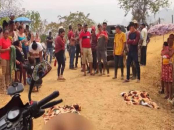 Lugareños observan los cuerpos de la madre y su hijo tirados en el suelo y cubiertos con mantas.