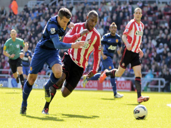 Sunderland's English defender Titus Bramble (C) Manchester United's Dutch striker, Robin van Persie (L) during the English Premier League football match between Sunderland and Manchester United at the Stadium of Light in Sunderland, England, on March 30, 2013. Manchester United won 1-0. AFP PHOTO/GRAHAM STUART“ RESTRICTED TO EDITORIAL USE. No use with unauthorized audio, video, data, fixture lists, club/league logos or “live” services. Online in-match use limited to 45 images, no video emulation. No use in betting, games or single club/league/player publications. ”