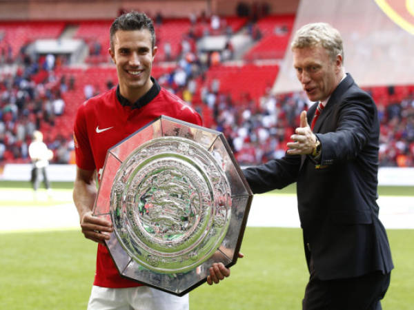 Manchester United's Robin Van Persie, left, poses with the trophy as manger David Moyes gestures after their win against Wigan Athletic at the end of their English FA Community Shield soccer match at Wembley Stadium in London, Sunday, Aug. 11, 2013. (AP Photo/Jon Super)