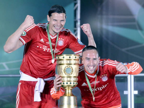 Bayern Munich's French midfielder Franck Ribery (R) and Bayern Munich's Belgian defender Daniel van Buyten celebrate with the trophy after they won the final football match of the German Cup (DFB - Pokal) FC Bayern Munich vs VfB Stuttgart on June 1, 2013 at the Olympic Stadium in Berlin. Champions League winners Bayern Munich became the first Bundesliga champion to win the treble after their hard-earned 3-2 win over plucky VfB Stuttgart in Saturday's German Cup final.AFP PHOTO / CHRISTOF STACHERESTRICTIONS / EMBARGO - DFL LIMITS THE USE OF IMAGES ON THE INTERNET TO 15 PICTURES (NO VIDEO-LIKE SEQUENCES) DURING THE MATCH AND PROHIBITS MOBILE (MMS) USE DURING AND FOR FURTHER TWO HOURS AFTER THE MATCH. FOR MORE INFORMATION CONTACT DFL