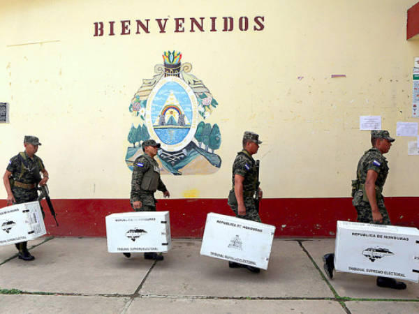 Honduran soldiers carry boxes with ballots at a polling station in Tegucigalpa on November 23, 2013. General election in Honduras will take place Sunday. AFP PHOTO/ Inti OCON