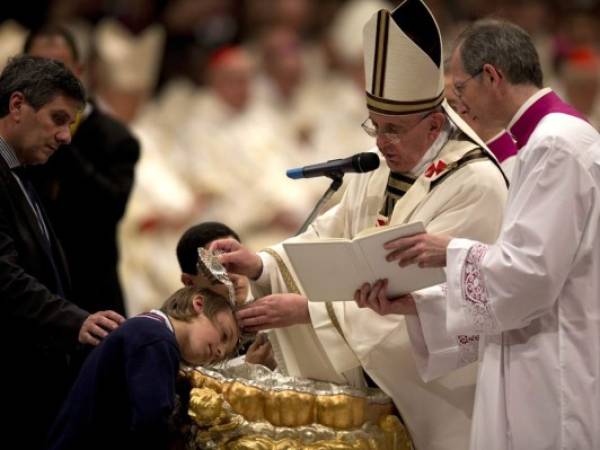 Pope Francis baptizes 10-year-hold Giorgio Capezzuoli during the Easter vigil service in St. Peter's Basilica, at the Vatican Saturday, April 19, 2014. Pope Francis baptized 10 people Saturday as he presided over an Easter Vigil in St. Peter's Basilica, fulfilling a ritual deep in meaning on the most solemn night of the Catholic calendar. Francis urged the priests, bishops, cardinals and ordinary Catholics gathered for the late night service to remember when they first found their faith. 'Do I remember it? Have I forgotten it? Look for it. You'll find it. The Lord is waiting.' (AP Photo/Alessandra Tarantino)