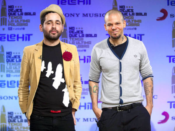 Rene Perez, right, and his brother Eduardo Martinez, of Puerto Rico's band Calle 13, pose for photos during a press conference in Mexico City, Thursday, Nov. 8, 2012. Calle 13 recently launched their new music video 'La Bala,' or The Bullet in English, in a joint venture with UNICEF. (AP Photo/Alexandre Meneghini)