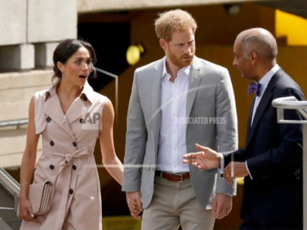 El príncipe Enrique, centro y su esposa Meghan, duquesa de Sussex, charlan con sir Kenneth Olisa al llegar a la inauguración de la exposición Nelson Mandela Centenary por el centenario del nacimiento del líder contra el apartheid en el Queen Elizabeth Hall en Londres el martes 17 de julio de 2018.