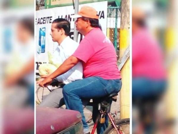 Un padre hondureño utiliza una bicicleta para llevar diariamente a su hijo, quien se dirige a su trabajo.