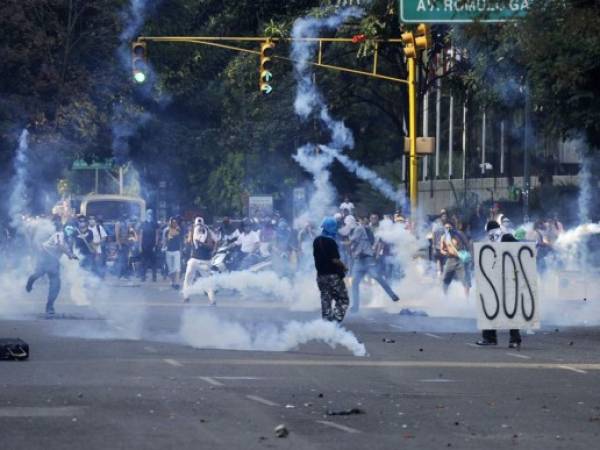 Demonstrators protest against the government of Venezuelan President Nicolas Maduro, in Caracas on March 8, 20145, 2014. Armed with cooking pots in a potent symbol of Venezuela's chronic food shortage, thousands took to the streets Saturday in the latest public rally against the government. At least 20 people have now died since protests first erupted, giving Maduro his biggest test since succeeding late leader Hugo Chavez almost a year ago. AFP PHOTO / LEO RAMIREZ