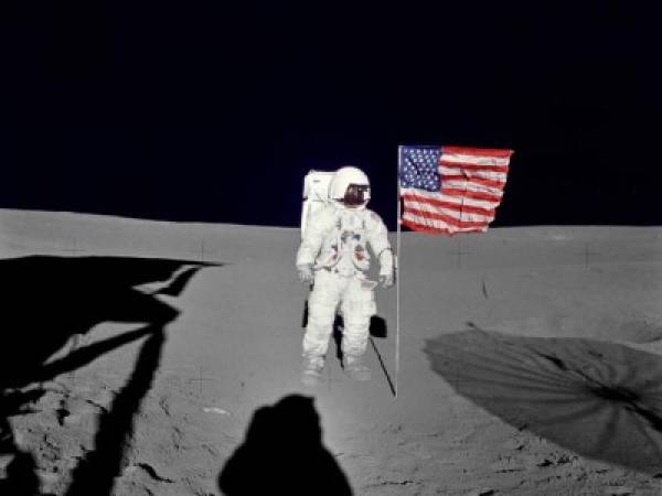 Esta imagen de la NASA sin fecha obtenida el 5 de febrero de 2016 muestra al astronauta Edgar D. Mitchell, piloto del módulo lunar del Apolo 14, de pie junto a la bandera estadounidense desplegada en la superficie lunar durante los primeros momentos de la primera caminata espacial de la misión. Foto AFP.