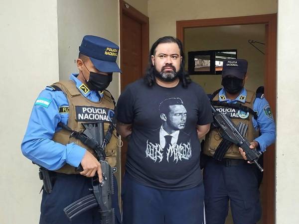 El abogado y presunto miembro de la MS-13, es custodiado por dos elementos de la Dirección Policial Anti Maras y Pandillas Contra el Crimen Organizado (Dipampco).