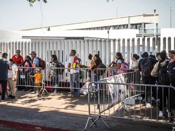 Migrantes hacen fila en la garita el Chaparral para cruzar la frontera hacia Estados Unidos, en la ciudad de Tijuana, en Baja California.