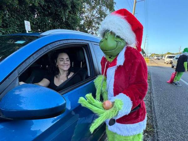 El coronel Lou Caputo, de la Oficina del Alguacil del Condado de Monroe, disfrazado de ‘Grinch’, ofrece una cebolla a una conductora que iba ligeramente con exceso de velocidad en una zona escolar este jueves.