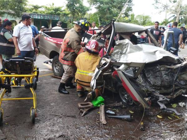 Miembros del Cuerpo de Bomberos rescataron a las personas que quedaron atrapadas en el amasijo de hierro que quedó convertido el pick up al chocar con el camión en la aldea Las Palmas de Tela, Atlántida.